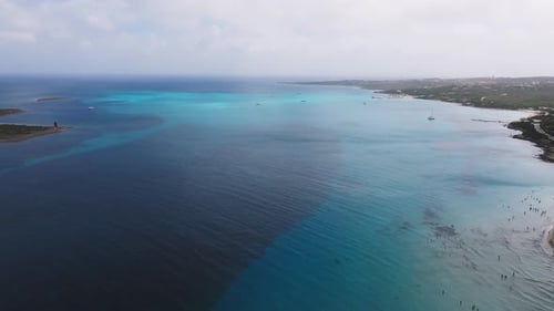 Aerial View of a Sardinian Beach with Turquoise Waters Sandy Shoreline and Beachgoers