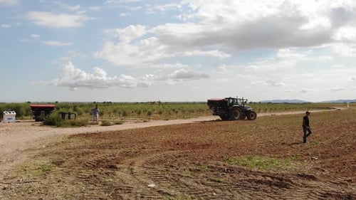 Tractor Spreading Fertilizer Across Rural Field