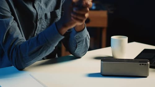 Person working on smart speaker device on desk
