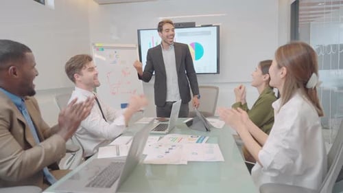 Caucasian manager stand in front of meeting room to present his work then his team clap hands