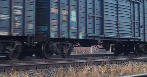 Freight Train Rolling on Railroad Tracks During Daytime