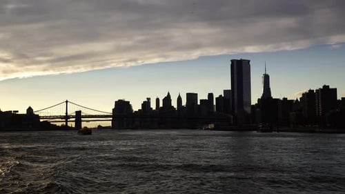 Silhouette of New York city and bridge during sunset, view from Hudson river