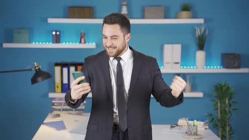 Excited Young Adult Celebrates Success on Smartphone