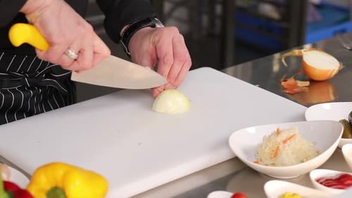 Chef Chopping White Onion on a Cutting Board