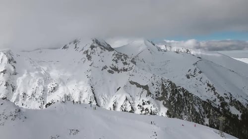 Vue panoramique prise par un drone en Slowmotion avec des skieurs et des snowboarders le long de la crête