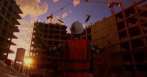 Back View Of A Male Engineer With Safety Helmet Spreading Arms At Construction Site