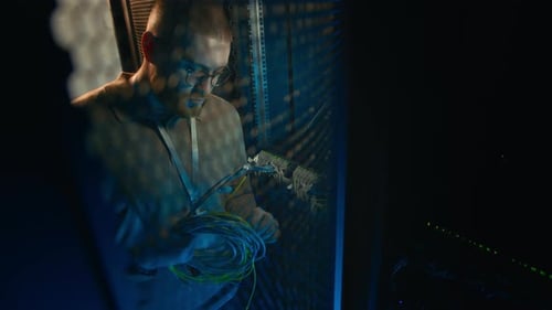 Technician Working in Dark Server Room