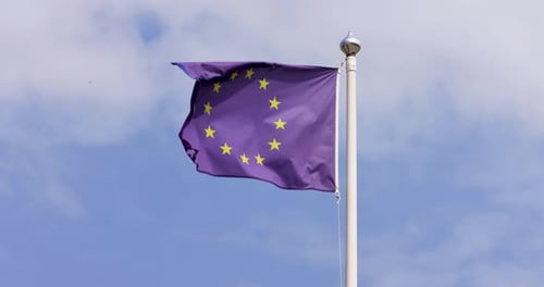 Zeitlupenaufnahmen einer EU-Europaflagge, die an einem sonnigen Sommertag im Wind weht
