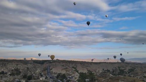 Hot Air Balloons Flying Over Rocky Landscape