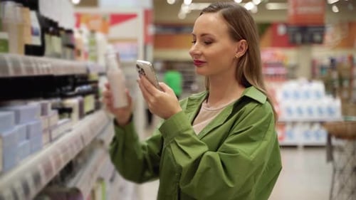 Woman Scanning Product Using Phone in Supermarket