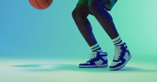 Video eines afroamerikanischen männlichen Basketballspielers, der Ball auf blauem Hintergrund hüpft
