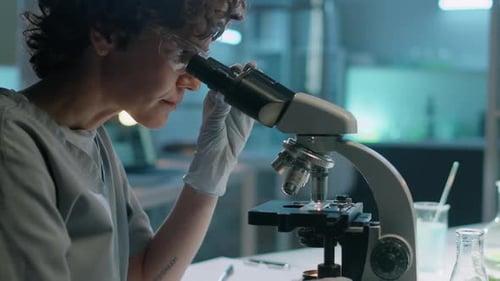 Young Adult Using Microscope in a Lab