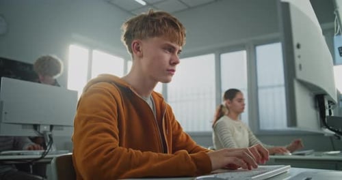 Jovem olha para a câmera enquanto aprende programação e design