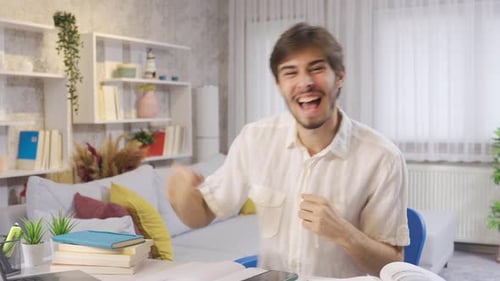 Excited Man Dancing at Desk in Bright Room