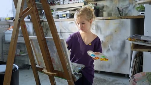 Young Girl Paints on Canvas in Art Studio