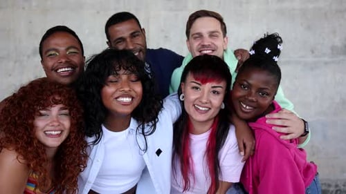 Multiracial lgbt friends standing closely together, radiating joy and unity while posing in front of