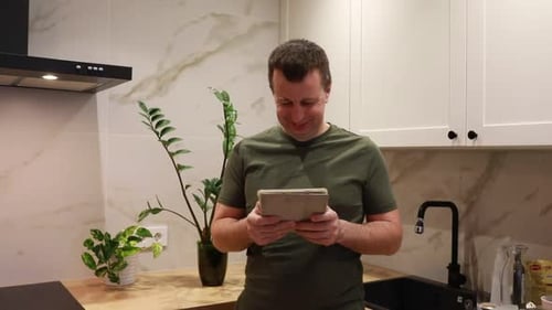 Man Uses Tablet in Modern Kitchen
