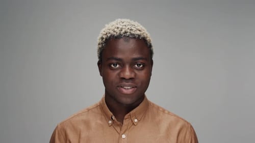 Young Adult Smiling in a Tan Shirt