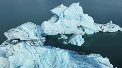 Iceberg no oceano: enormes pedaços de gelo azul flutuando nas ondas, paisagem ártica, vista aérea