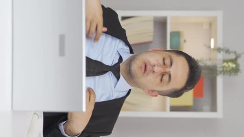 Vidéo verticale d'un employé de bureau à domicile qui suffoque à cause de la chaleur.