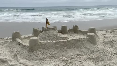 Sand castle on a sleepy beach vacation background.