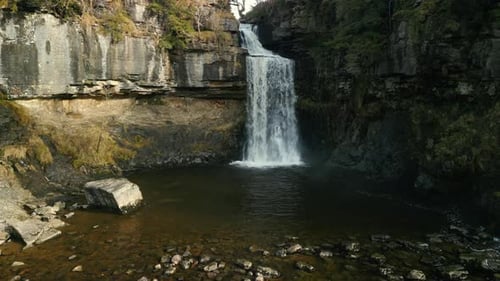 Slow motion waterfall approach in winter at Ingleton Waterfalls Trail Yorkshire UK