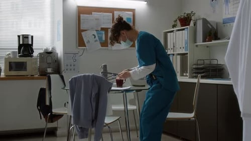 Stressed Doctor Working in Hospital Break Room