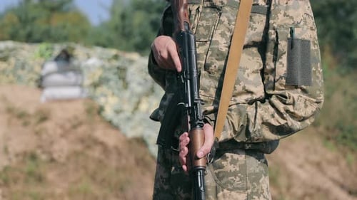 Soldier Holding an Assault Rifle During Field Operations A Ukrainian Soldier in Camouflage Uniform