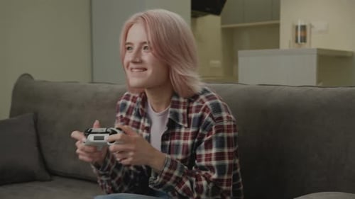 Woman Playing Video Game on Couch at Home