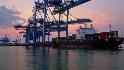 A Container Ship Has Successfully Docked at the Port During a Beautiful Sunset Scene