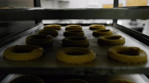 Kitchen in a bakery - a bun (bagel) on a baking sheet before baking in a bakery