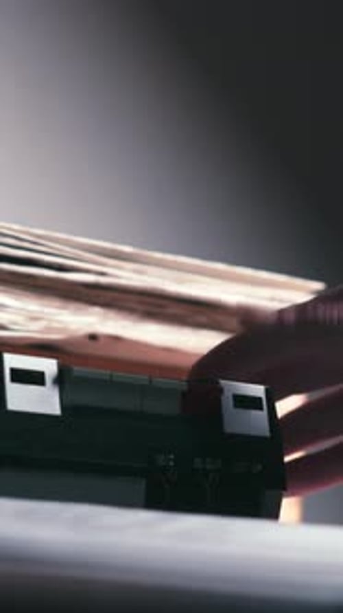 Hand inserting cassette into retro audio recorder Vertical close-up