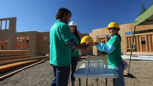 Volunteers Putting On Hard Hats at Construction Site