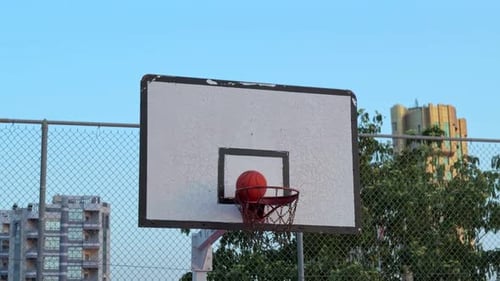 Basketball wurde mitten in der Luft in Richtung Hoop auf dem Urban Court im Freien geschossen