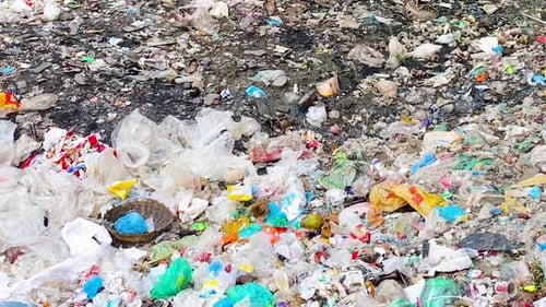 Piles of garbage at landfill, panning view