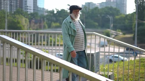 Live Camera Follows Confident Old Man Walking Downstairs From Pedestrian Bridge Strolling in Urban