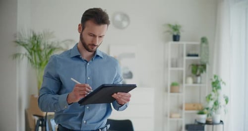 Young Adult Man Using Tablet in Office Setting