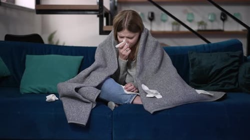 Sick Woman Crying on Couch with Blanket