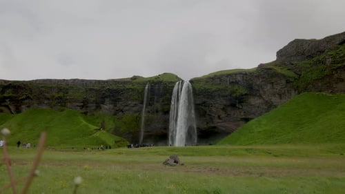Seljalandsfoss Waterfall Plunging Down Green Cliffside in Beautiful Iceland Landscape