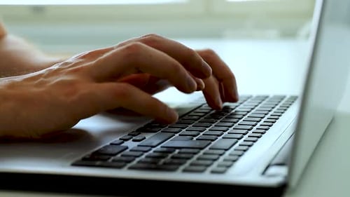 Close up of hands typing with a laptop