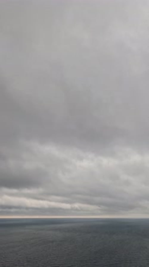 Lapso de tiempo: nubes lluviosas del Nimbostratus moviéndose en un brillante cielo al atardecer sobre un mar tormentoso Vista aérea abstracta