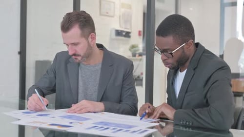 Multi Ethnic People Discussing Paperwork in Office