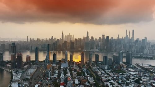 Manhattan in the haze of sunset. New York skyline under the orange cloudscape. Top view.