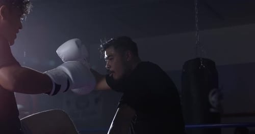 Two fighters inside ring battling each other in super slow-motion at 800 fps. Warrior punching
