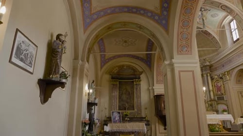 An inside tilting up of view of an Catholic Church, Having beautiful and antique art work.