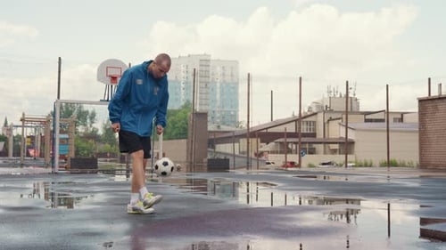 Rainy Court Focus Man Practices Basketball Skills on Wet City Pavement An Adult Male Demonstrates