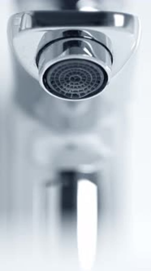 Water Dripping Slowly From Shiny Chrome Bathroom Faucet