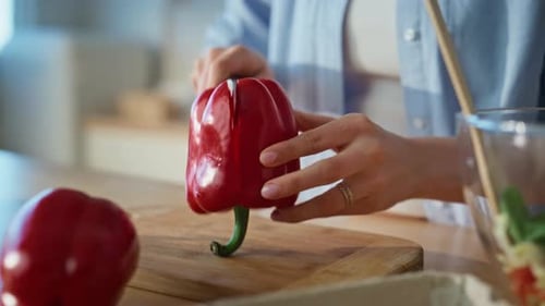 Woman Cuts Red Pepper in Sunny Kitchen