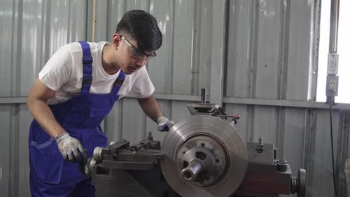Man Working on Metal Machine in Workshop