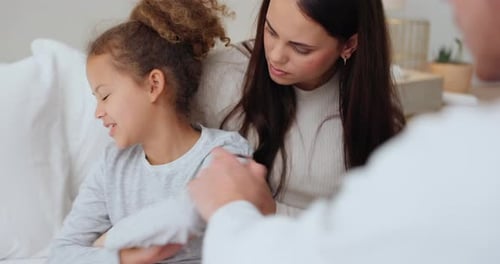 Doctor Examines Child at Home with Mother Present